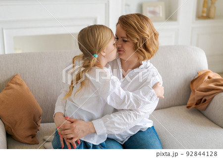Portrait happy family, single mother and baby daughter hugging on sofa at home Portrait happy family, single mother and baby daughter hugging on sofa at home 92844128