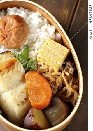 大きめの梅干しがご飯の上に乗っていて玉子焼や煮物なども入っている銀だらの西京焼き弁当を俯瞰で撮影 大きめの梅干しがご飯の上に乗っていて玉子焼や煮物なども入っている銀だらの西京焼き弁当を俯瞰で撮影 92844682