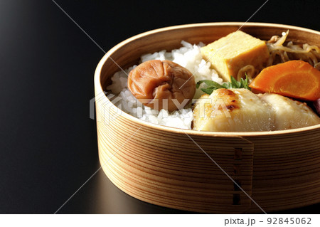 大きめの梅干しがご飯の上に乗っていて玉子焼や煮物なども入っている銀だらの西京焼き弁当を黒背景で撮影 大きめの梅干しがご飯の上に乗っていて玉子焼や煮物なども入っている銀だらの西京焼き弁当を黒背景で撮影 92845062