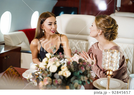 Beautiful happy women chatting and laughing while celebrating at table Beautiful happy women chatting and laughing while celebrating at table 92845657