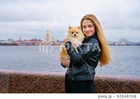 Lifestyle image of happy attractive young woman in black leather jacket walking Lifestyle image of happy attractive young woman in black leather jacket walking 92846508