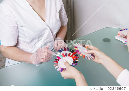 Beauty saloon. Master together with client, chooses color of gel polish Beauty saloon. Master together with client, chooses color of gel polish 92846607