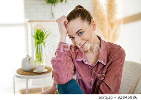 Calm young caucasian woman sitting on a comfortable chair and enjoying Calm young caucasian woman sitting on a comfortable chair and enjoying 92846986