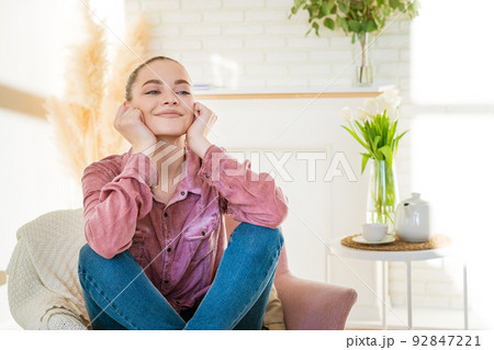 Smiling caucasian millennial girl sitting resting in chair in casual clothes 92847221