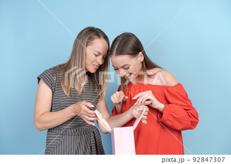 Happy mom and daughter are looking at fun shopping daughter is gesturing Happy mom and daughter are looking at fun shopping daughter is gesturing 92847307