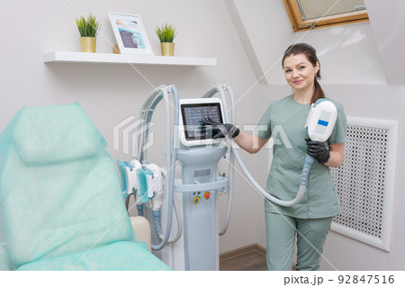 Woman doctor in medicine salon holds vacuum massage apparatus. Anti-cellulite Woman doctor in medicine salon holds vacuum massage apparatus. Anti-cellulite 92847516