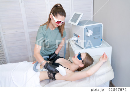 Laser hair removal in beauty salon. Woman has removal procedure, caucasian girl 92847672