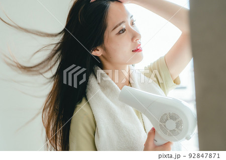 髪を乾かす女性 92847871