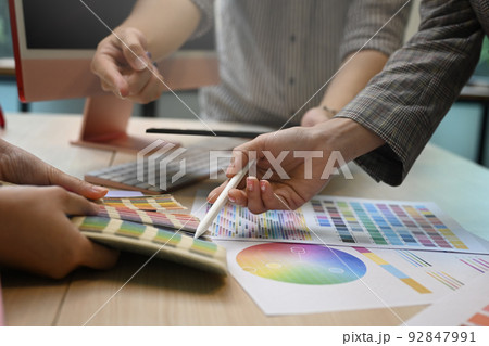 Graphic designers team working with color swatches and brainstorming for new project at creative office Graphic designers team working with color swatches and brainstorming for new project at creative office 92847991