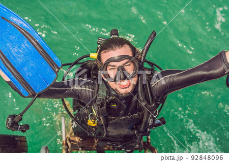 Happy diver returns to the ship after diving Happy diver returns to the ship after diving 92848096