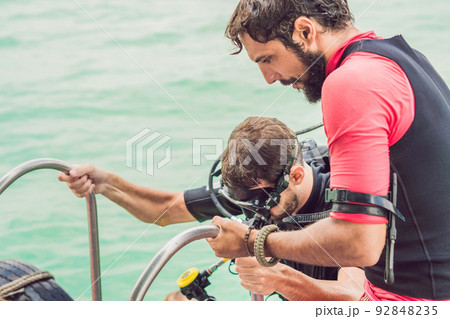 Happy diver returns to the ship after diving Happy diver returns to the ship after diving 92848235