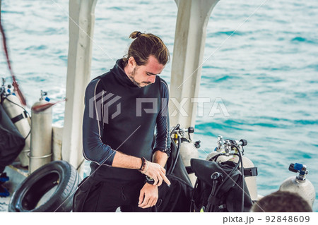 Young diver preparing an underwater compass for diving 92848609