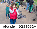 Feeding pigeons in the park. Girl feeds pigeons in London park 92850920