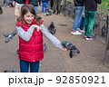 Feeding pigeons in the park. Girl feeds pigeons in London park 92850921