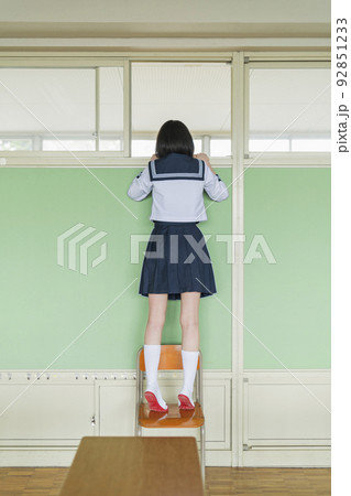 教室 廊下を見る女子高生 92851233