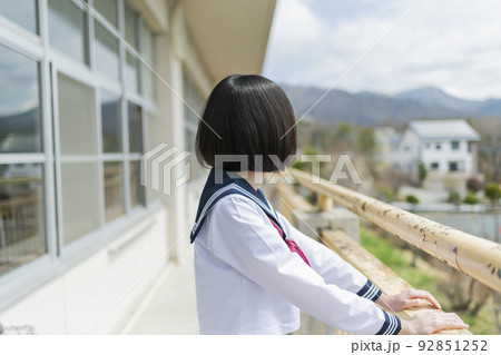 学校 ベランダ 校庭を見る女子高生 92851252