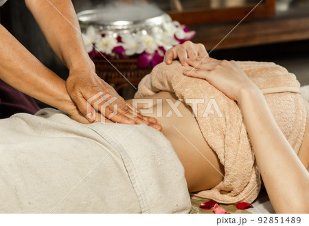 Asian woman enjoying a salt scrub massage at spa. Healthcare spa and massage thai concept Girl receiving holistic massage treatment thai masseuse woman getting massage Asian woman enjoying a salt scrub massage at spa. Healthcare spa and massage thai concept Girl receiving holistic massage treatment thai masseuse woman getting massage 92851489