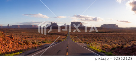 Scenic Road in the Dry Desert with Red Rocky Mountains in Background. 92852128