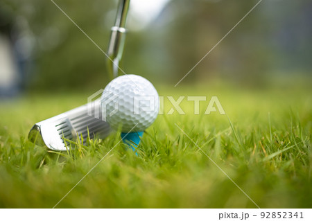 Golf ball on tee in front of driver Golf ball on tee in front of driver 92852341
