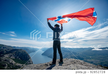 Woman with a waving flag of Norway on the background of nature 92852728