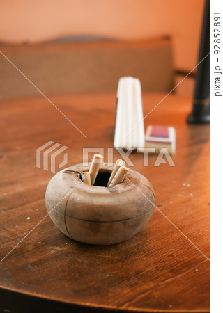 Close up burning cigarette in ashtray on table Close up burning cigarette in ashtray on table 92852891