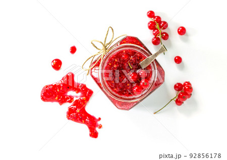 Homemade jam. Glass jar with red currant jam on white background. Preserved berry. Top view. 92856178