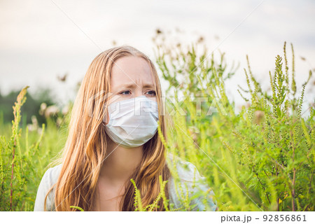 Young woman in a medical mask because of an allergy to ragweed Young woman in a medical mask because of an allergy to ragweed 92856861