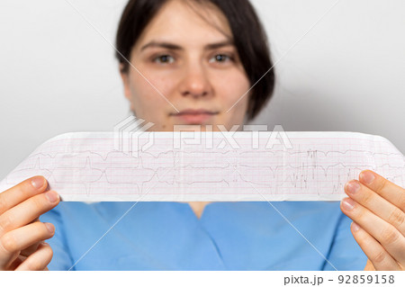 The cardiologist shows the film of an electrocardiogram of a patient with acute myocardial infarction. Heart and cardiovascular disease, cardiology and cardiography The cardiologist shows the film of an electrocardiogram of a patient with acute myocardial infarction. Heart and cardiovascular disease, cardiology and cardiography 92859158