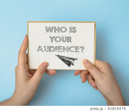 Person holds card with words Who is your Audience on blue Person holds card with words Who is your Audience on blue 92859479