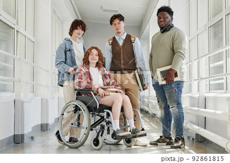 Group of multicultural teenage students in casualwear standing in corridor 92861815