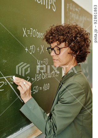 Young confident teacher in eyeglasses and smart casualwear drawing angle 92861863