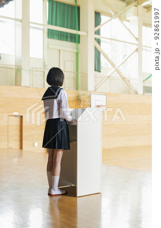 体育館 ステージでスピーチをする女子高生 体育館 ステージでスピーチをする女子高生 92861997
