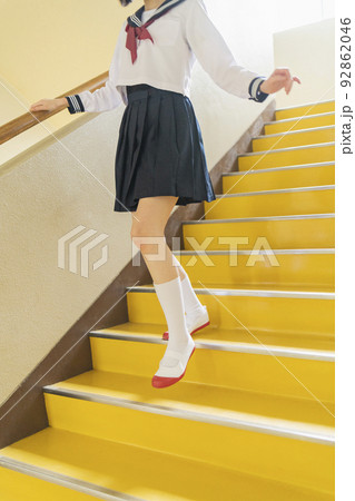 学校 階段をかけ降りる女子高生 92862046