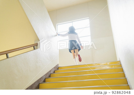 学校 階段をかけ上がる女子高生 92862048
