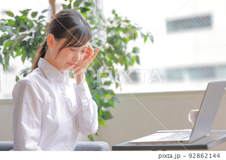 頭痛を感じるデスクワークの女性1 頭痛を感じるデスクワークの女性1 92862144