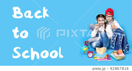 Back to school. Portrait of school girl, Girls sisters in glasses sit floor on blue background Back to school. Portrait of school girl, Girls sisters in glasses sit floor on blue background 92867816