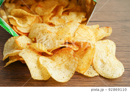 Potato chips in open bag, delicious BBQ seasoning spicy for crips, thin slice deep fried snack fast food in open bag. 92869110