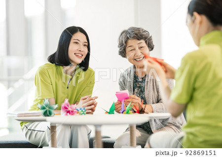 折り紙を折る介護士とシニア女性 折り紙を折る介護士とシニア女性 92869151