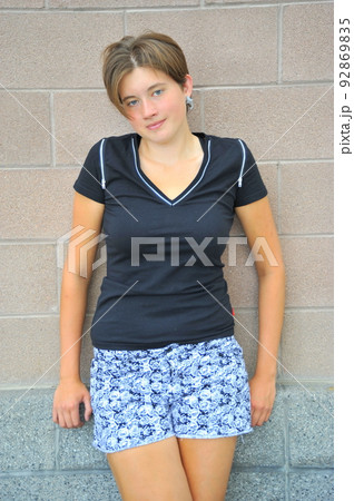 Female beauty expressions against a wall outside. 92869835