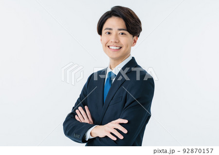 白バックで腕を組むスーツを着た若い男性 92870157