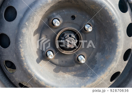 Bolts with unscrew nuts from a car wheel. Bolts with unscrew nuts from a car wheel. 92870636