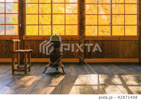 達磨ストーブと窓から見える銀杏の木	 92871408