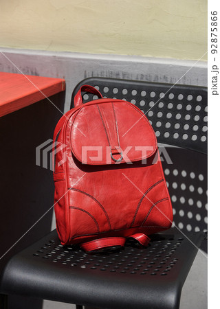 Red leather casual unisex backpack on a black chair 92875866
