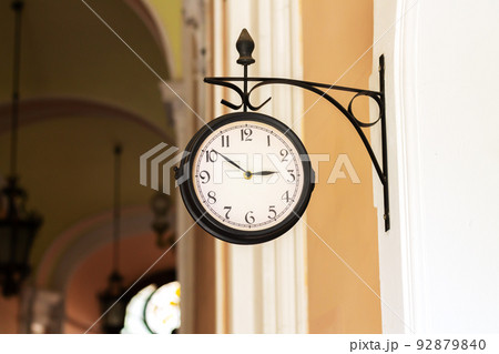Old analog clock on building wall outdoors Old analog clock on building wall outdoors 92879840