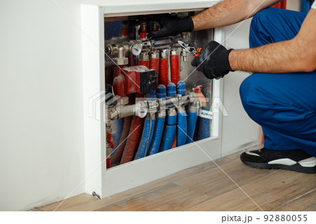 Cropped shot of technician, plumber in protective gloves checking water pipes and meter counter 92880055