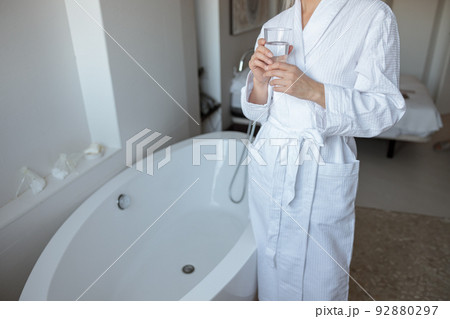 Woman standing near the buthtub in hotel room 92880297