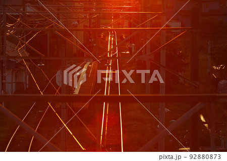 夕日の光と線路と電線 92880873