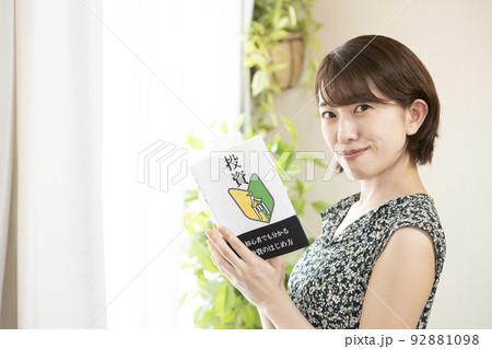 投資の本を読んで微笑む女性 投資の本を読んで微笑む女性 92881098