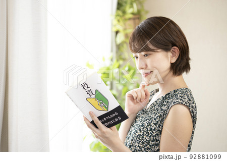 笑顔で投資の本を読む女性 92881099