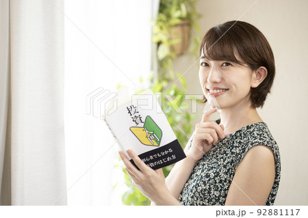 投資の本を読んで微笑む女性 92881117